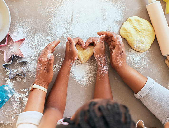 Hands using cookie cutters